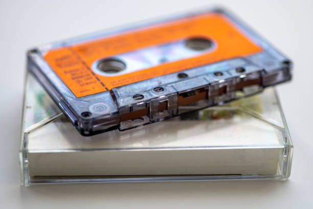 Close up of a old music cassette tape and its holder isolated in white.