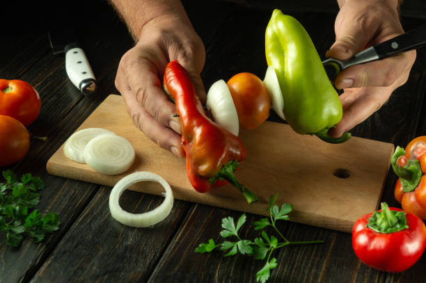 istock Preparing vegetables for baking. Red pepper is skewered on a fork by the chef hands. Vegetable breakfast menu concept 2173425956