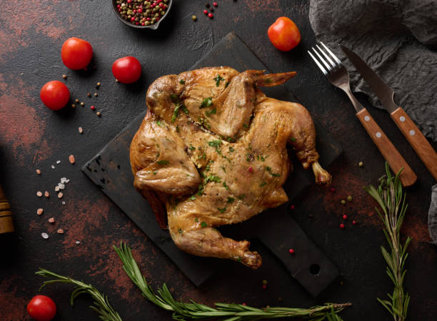 istock Baked chicken on a cutting board with rosemary, cherry tomatoes 2173429614