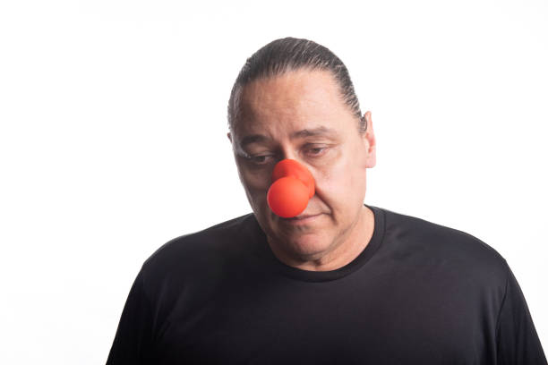 istock Adult man with clown nose posing, selective focus, white background. 2173429646