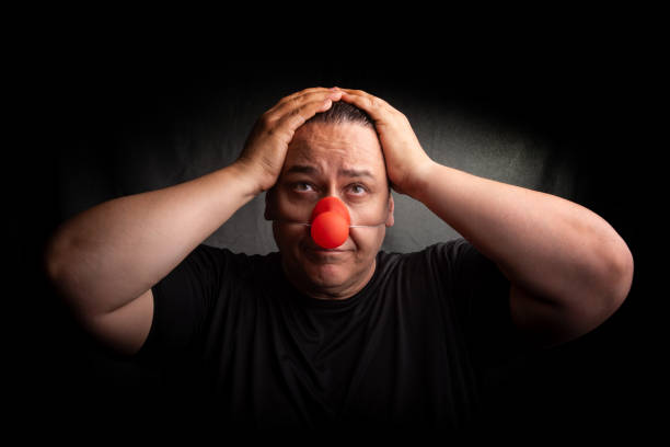 istock Adult man with clown nose, selective focus, dark background. 2173429795