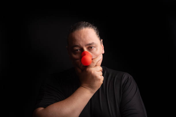 istock Adult man with clown nose, selective focus, dark background. 2173429828