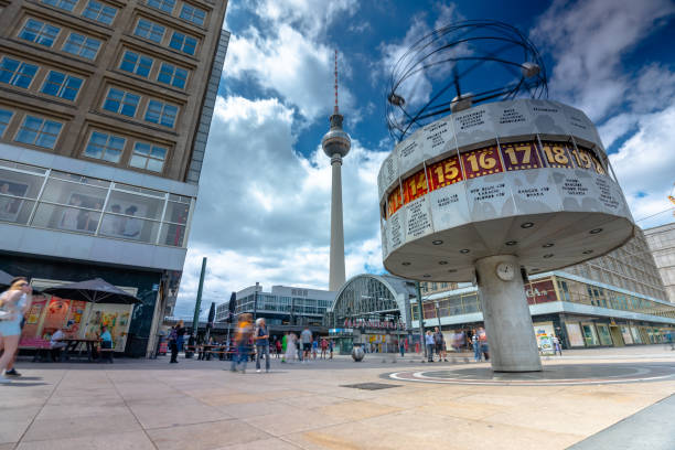 Berlin, Germany - June 23, 2024: Alexanderplatz World Time Clock. Tv tower on the background. Sunny day, medium cloudy sky. Long exposure shot.