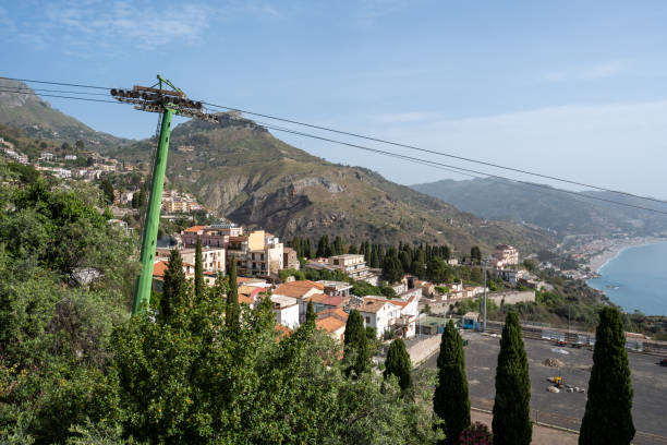 Taormina, Italy - June 19, 2024: Cityscape view. A cable car support column on the left.