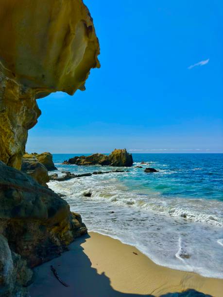 Rocky coastline, clear water, beach houses, and cliffs in Orange County, California
