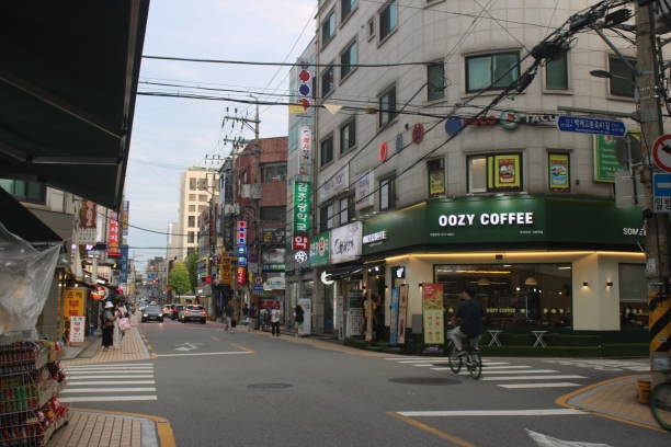 Seoul, South Korea-September 19, 2024: Dusk view of people walking down major commercial avenue, lined with shops, bars, and restaurants, in downtown Jamsil, Seoul