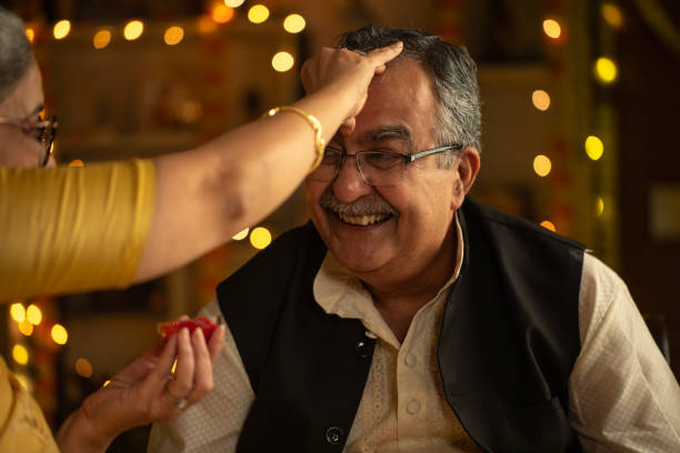 istock Senior woman applying tilaka on husband's forehead at home 2173439844