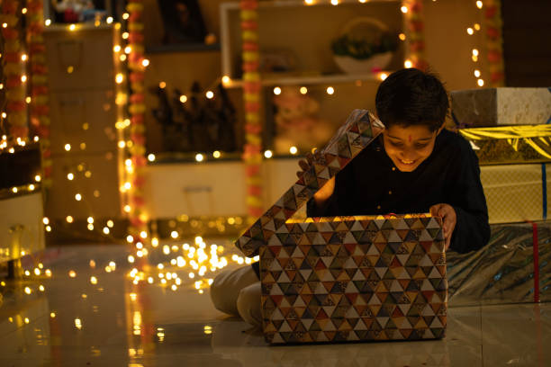 istock Excited boy opening Diwali gift in illuminated home 2173443502
