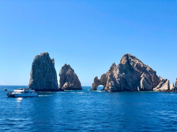 istock a boat in the water by large rocks 2173447653