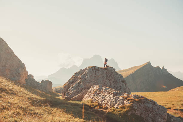 istock Young woman stands on boulder in mountain meadow 2173471066