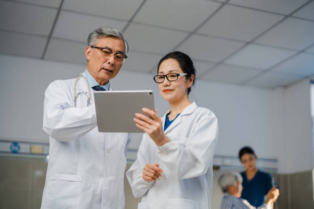 istock Two Asian senior doctors using digital tablet and discussing patient case in hospital ward. 2173475172