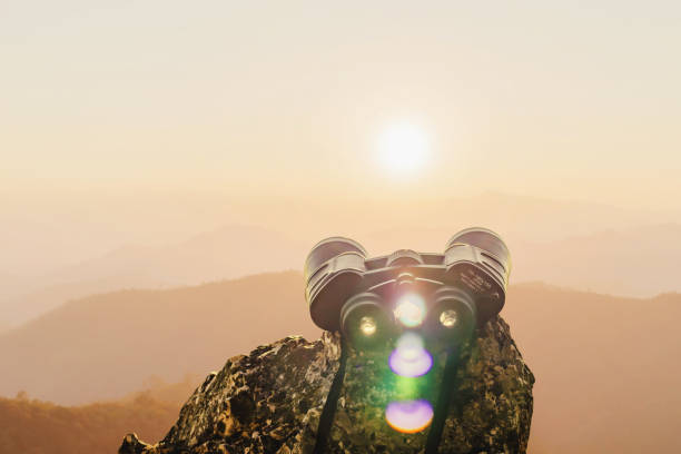 istock binoculars on top of rock mountain at beautiful sunset background. 2173481716
