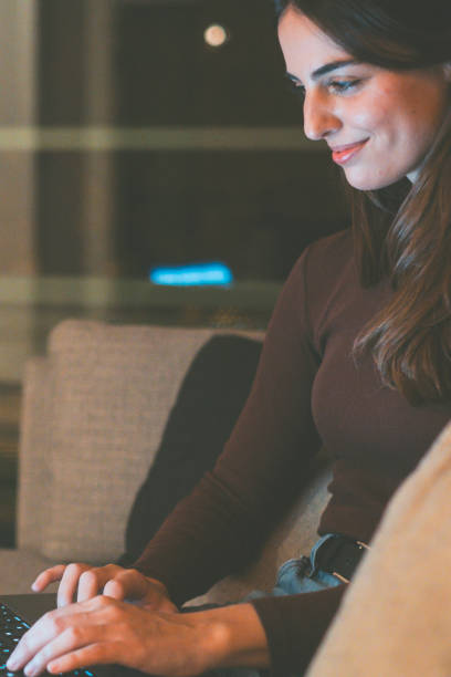 istock Late-night study session: A smiling university student sits on a couch, working on her laptop and browsing the web for useful results, preparing for exams and her future career in a focused and determined manner 2173487825