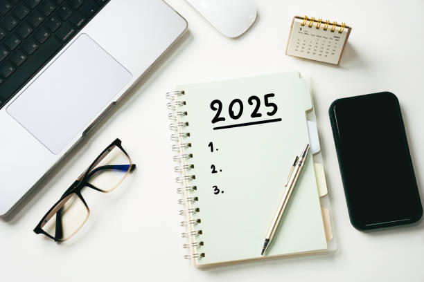 istock 2025 New Year goal plan action concept. 2025 goals Text on Note Pad with calendar glasses laptop and smartphone on table. New Year resolutions top view with copy space 2173488783