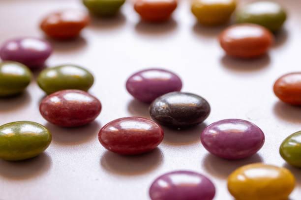 Colorful milk chocolates on rotating pink plate in close-up