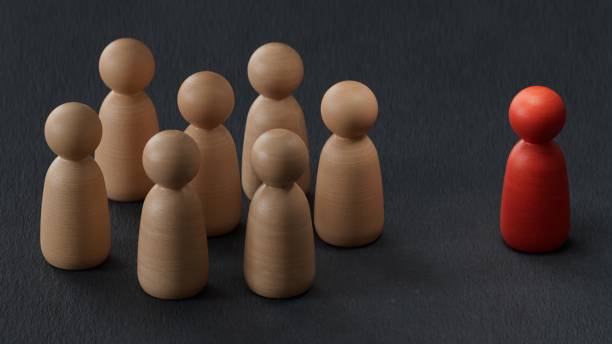 istock Concept of discrimination. Single red wooden peg standing away from a group.3D rendering on black background. 2173501895