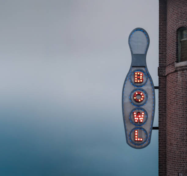A Retro Vintage Americana Image Of A Neon Sign For A Bowling Alley, At Dusk, With Copy Space