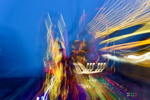 Colorful abstract blur of carnival lights in motion at night, creating swirling, vibrant patterns against a dark sky.