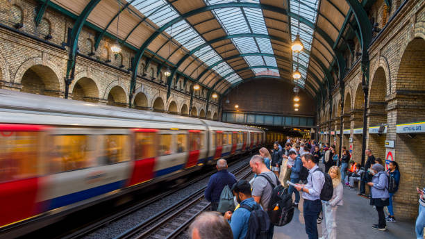 Notting Hill Gate, London, England - September 4, 2024: Commuters wait at Notting Hill Gate Station as a London Underground train rushes past  capturing the busy city life of London