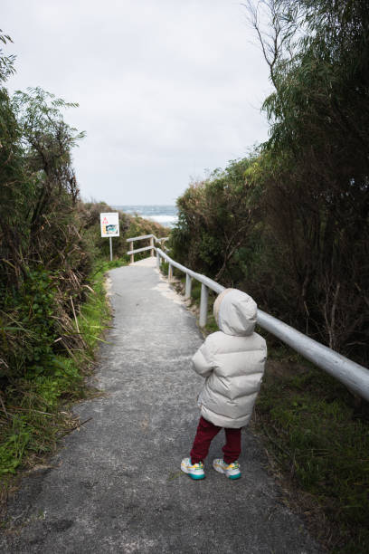 young child walking on the pedestrian going to beach