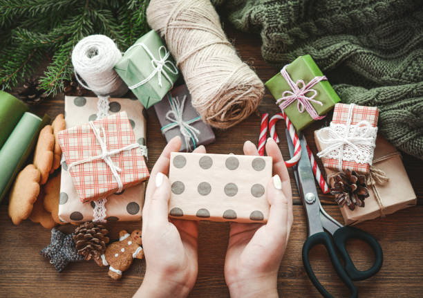 istock hands wrap christmas presents in craft paper 2173516188