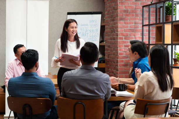 istock Female coach engages a group of business professionals through interactive session and strategic teamwork 2173518285