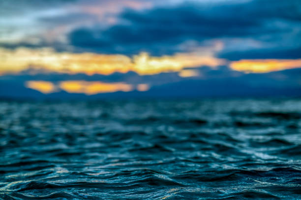 Bright clouds at yellow sunset and waves