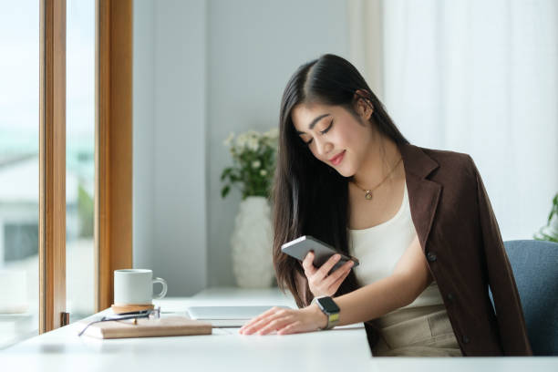 istock Attractive businesswoman sitting at modern workplace and using her mobile phone. 2173535543