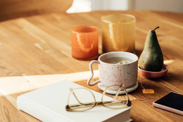 Lemon ginger tea on table with book and candlesPhoto taken indoors on kitchen table