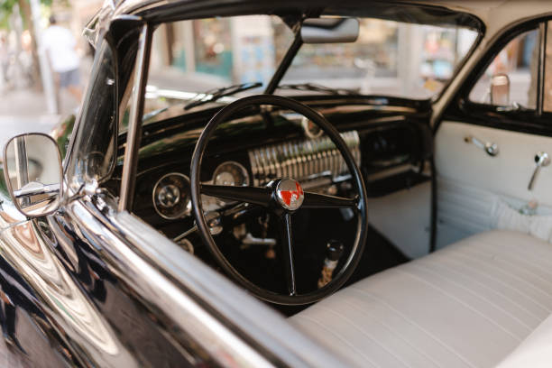 istock A vintage car with a black steering wheel and a white dashboard 2173543019