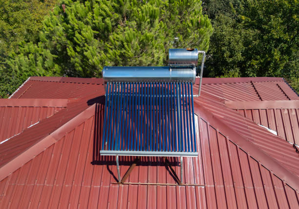 A modern solar pressure collector to heat domestic hot water, standing in front of the house on the lawn.