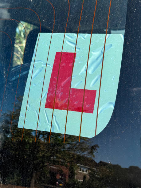 istock Image of l-plate car parked with windshield clearly displaying learner driver sign / a symbol of learning to drive 2173550665