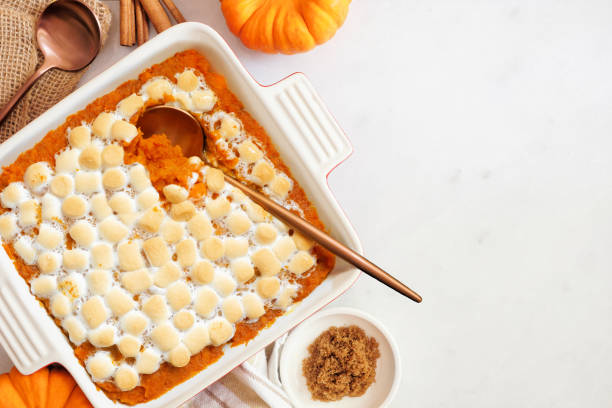 istock Sweet potato casserole with toasted marshmallows. Top view table scene on a white marble background with copy space. 2173555517