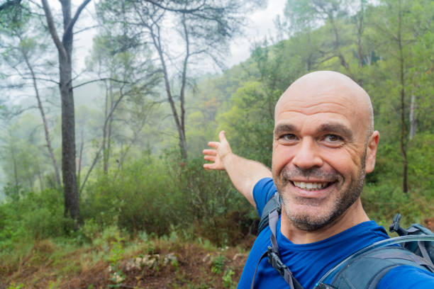 istock Happy hiker takes a selfie looking at camera, in a forest 2173557236
