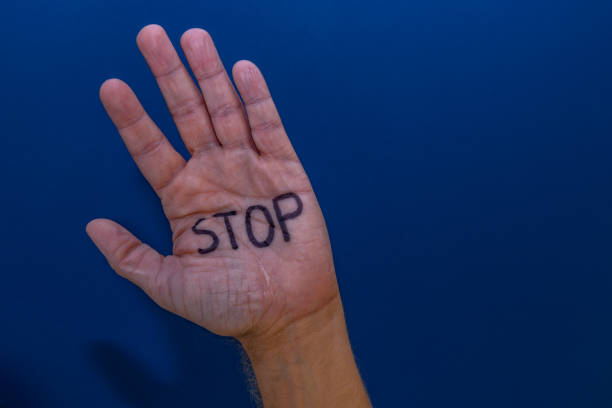 istock Men's hand on a blue background with the word STOP 2173558015