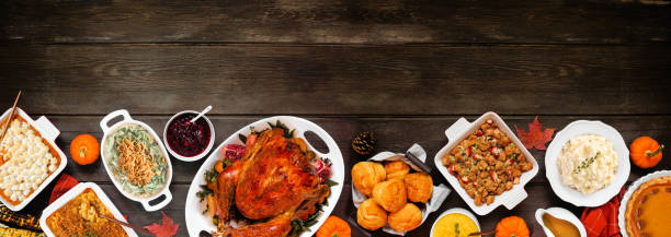 istock Traditional Thanksgiving turkey dinner bottom border on a rustic dark wood banner background 2173558245