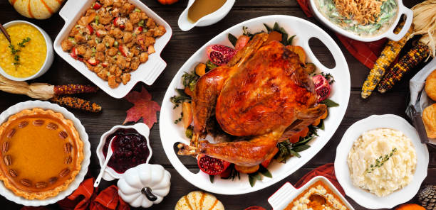 istock Traditional Thanksgiving turkey dinner table scene on a rustic dark wood banner background 2173558249