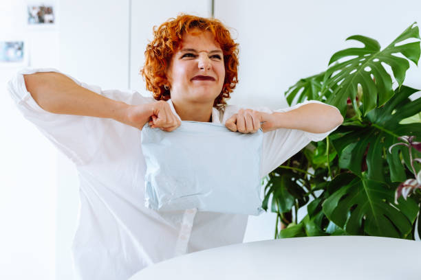 istock young red-haired attractive woman unpacking parcel at home 2173563375