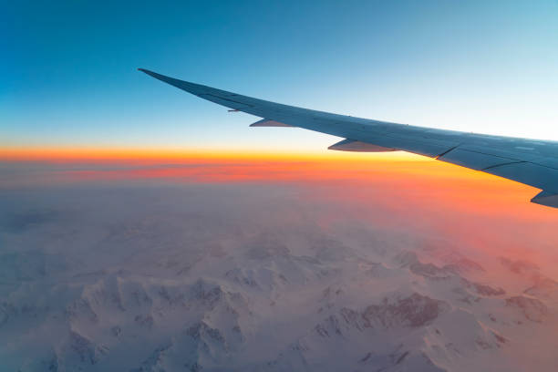 istock airplane wing above snow mountain in sunrise light 2173568567