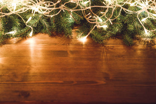 christmas lights on christmas tree on wooden background