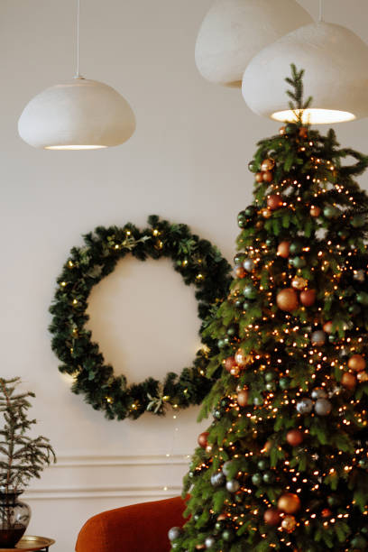 istock A Christmas tree with a wreath on the wall behind it 2173582920