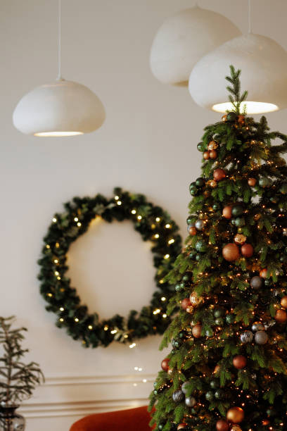 istock A Christmas tree with a wreath on the wall behind it 2173583373