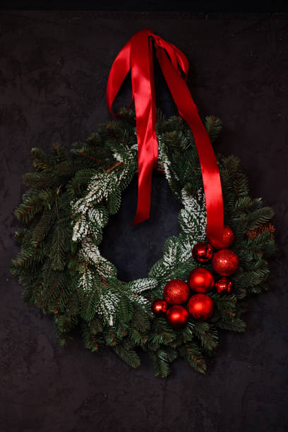 Step by step instruction of making handmade Christmas wreath made of festive decorations in red color. Female hands creating craft homemade decor. New year celebration. Winter holidays Step 4
