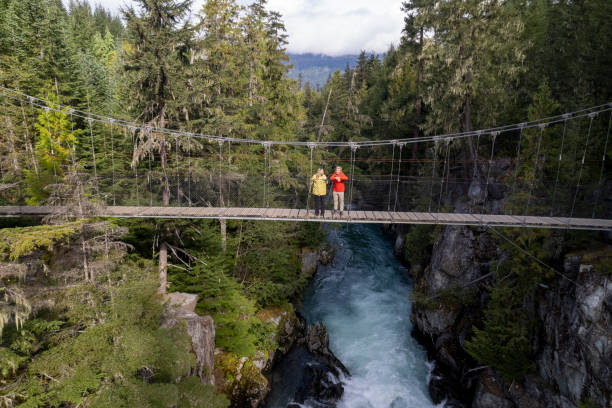 istock Mature couple cross suspension bridge over river 2173586025