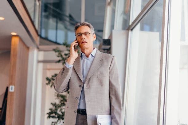 istock Businessman talking on phone and holding documents confidently in the office 2173588113