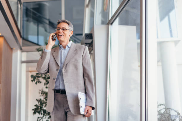 istock Businessman talking on phone and holding documents confidently in the office 2173588129