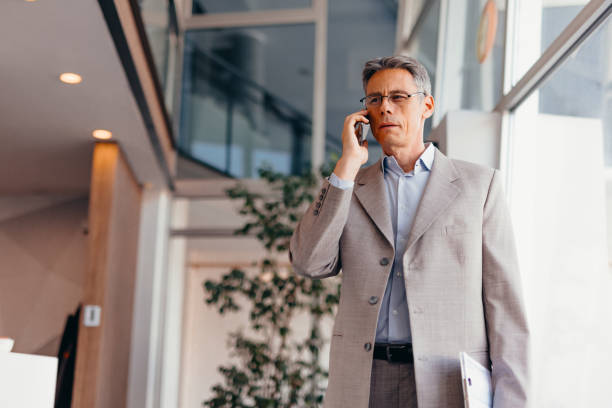 istock Businessman talking on phone and holding documents confidently in the office 2173588131