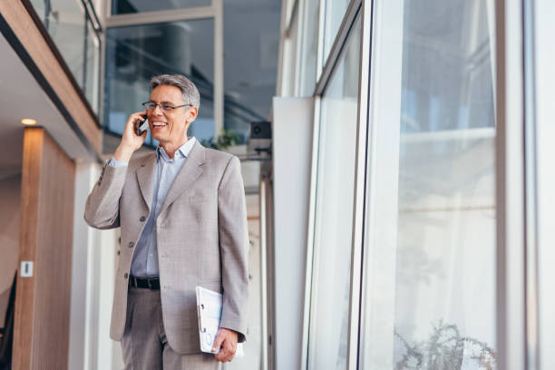 istock Businessman talking on phone and holding documents confidently in the office 2173588134