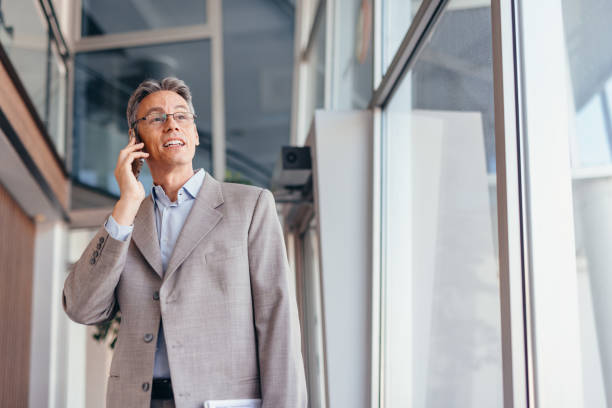 istock Businessman talking on phone and holding documents confidently in the office 2173588141