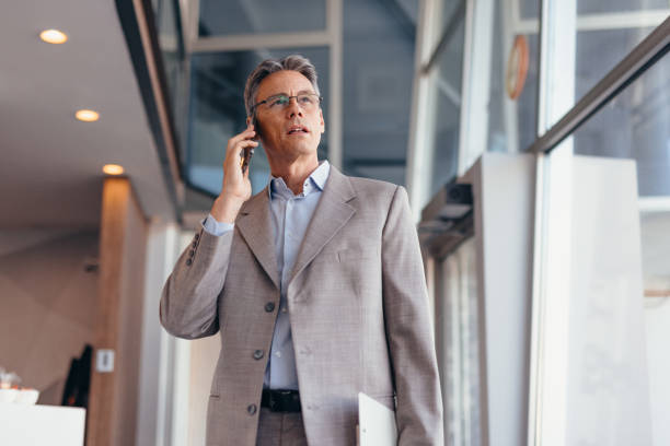 istock Businessman talking on phone and holding documents confidently in the office 2173588198